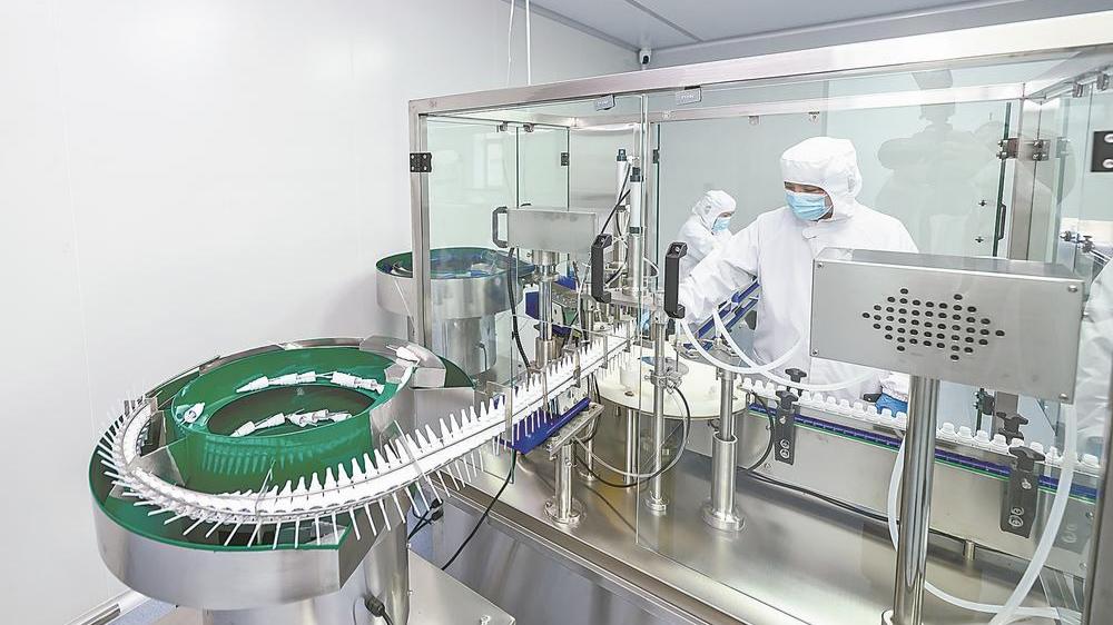 工人正在自主研发、新近投产的抑菌液产品生产线上调试机器