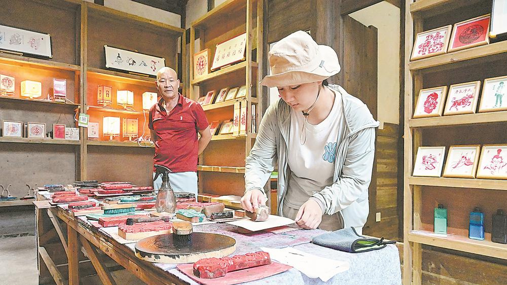 游客在培田古村落体验四堡雕版印刷技艺